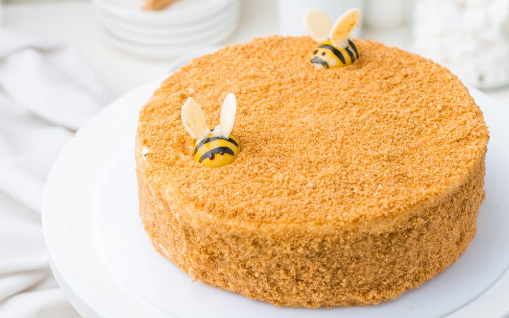 Yellow cake with two bees as decoration. 