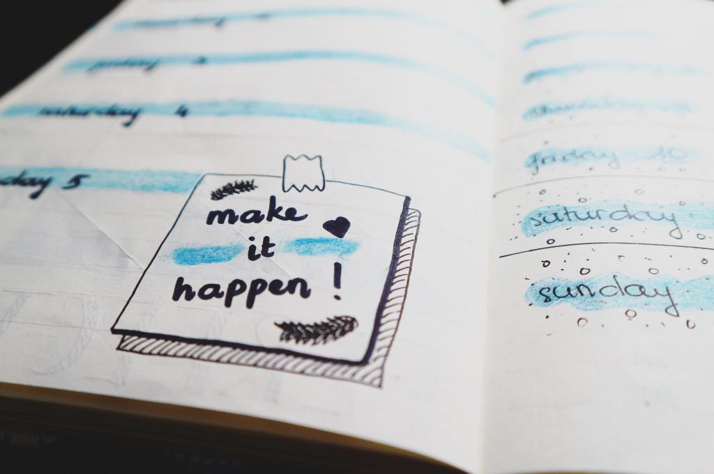 A journal with a note that says "make it happen!".