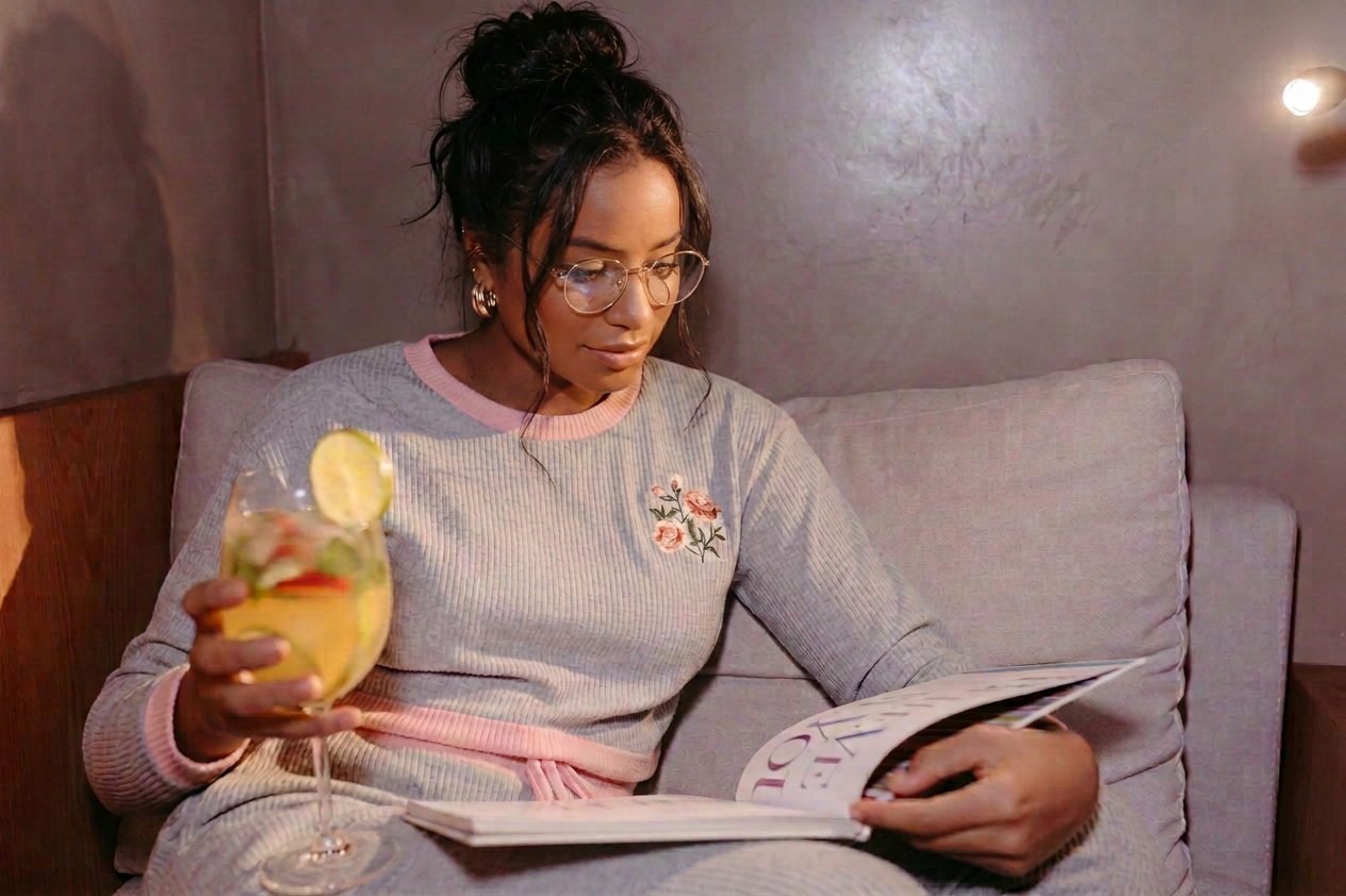 woman reading a catalog while holding a cocktail